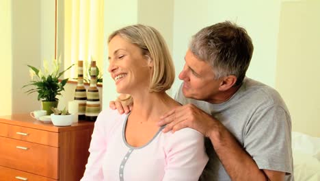 Attentive-man-massaging-his-wifes-shoulders