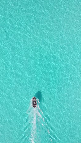 a vertical shot of a boat in the turquoise water