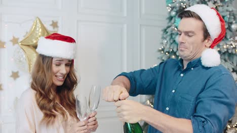 Pareja-Sonriente-Celebrando-El-Año-Nuevo-Con-Champán-En-Sombreros-De-Santa.