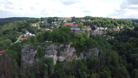 aerial footage of drone approaching medieval town and castle on top of a rock formation in east germany