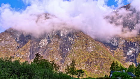 tiro de lapso de tiempo de nubes flotantes y niebla entre montañas durante el día soleado en verano - hojas verdes de árboles en el valle