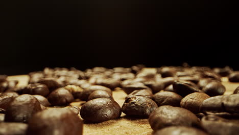 cierre el movimiento de la cámara a través de granos de café frescos sobre una superficie de madera