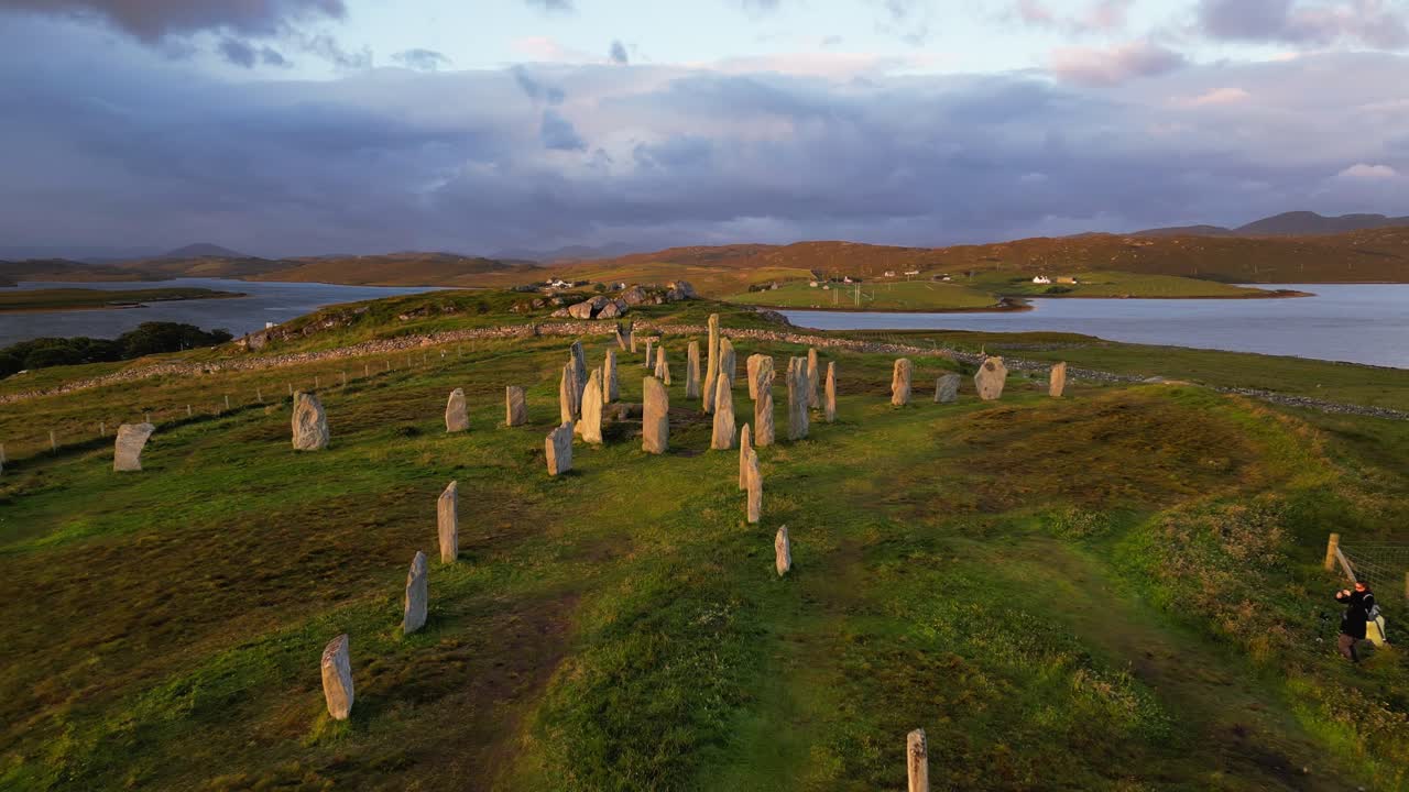 Flying above Callanish standing stones avenue at sunrise on cloudy day
