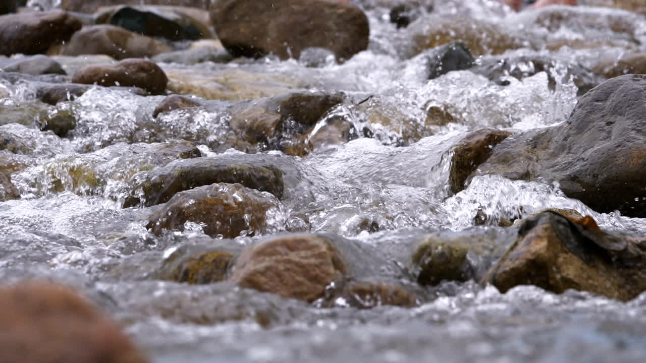 Ruscello limpido che scorre tra massi di pietra. Fiume copioso che scorre al rallentatore.