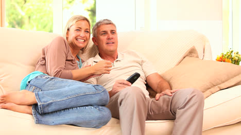 young couple getting excited watching programme on tv