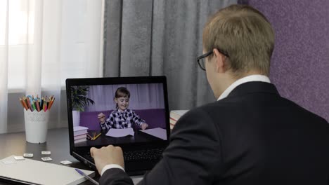 man teacher makes video call on laptop with children pupil. distance education