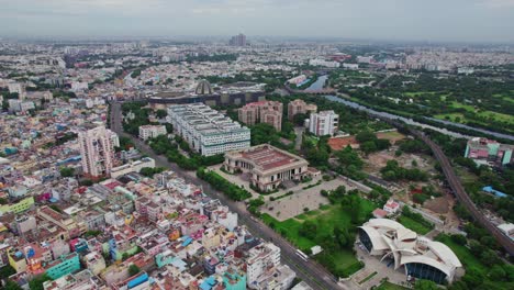 aerial view of wallahjah road with crowded building, state guest house, kalaivanar arangam and government medical college in chennai, tamil nadu, india. daytime, push in, drone shot, 4k.