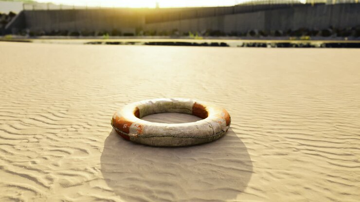 Lifebuoy nestled upon warm sands at sunset near quiet shoreline
