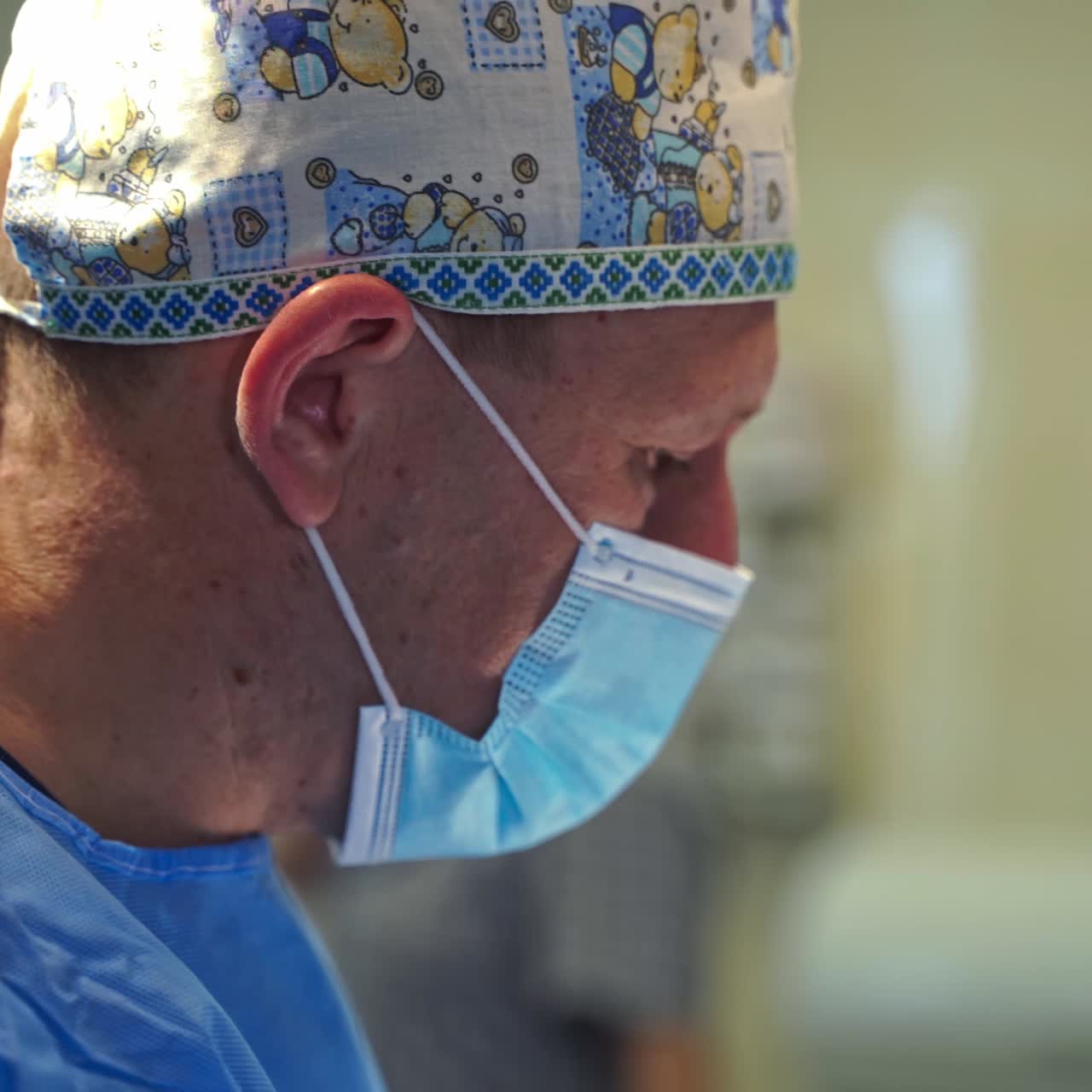 Portrait of a confident surgeon at work. Adult professional performing operation. Side view