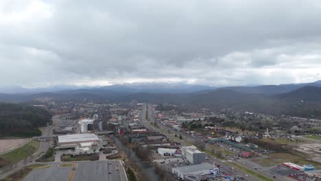 aerial shot over piegon forge, tn with snow covered smoky mountains in the background.