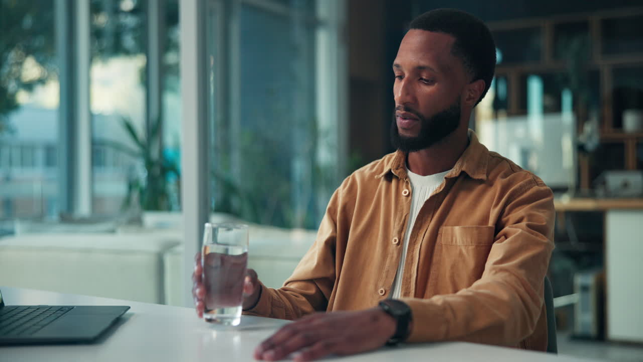 Man drinking water at his desk