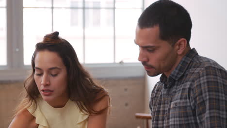 dos jóvenes creativos intercambiando ideas en el trabajo, de cerca