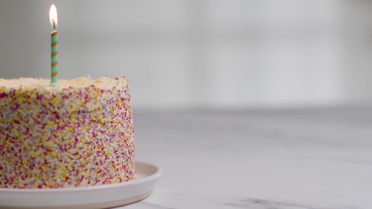 장식으로 덮인 스튜디오 샷 생일 케이크와 하나의 촛불이 날아가는 것 2