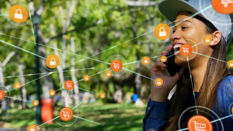 Animation-of-network-of-connected-icons-in-circles-over-happy-biracial-woman-using-smartphone