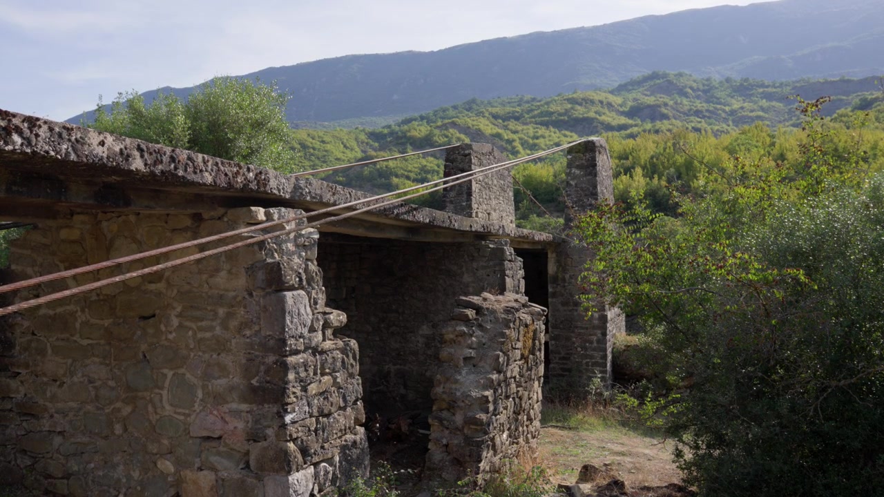 Rovine in pietra erose dal tempo immerse in un rigoglioso paesaggio rurale montuoso e collinare