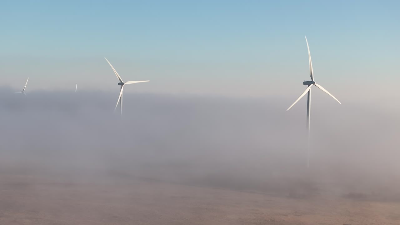 안개 가 가득 한 땅 은 이른 아침 에 풍력 발전소 를 둘러싸고 있다