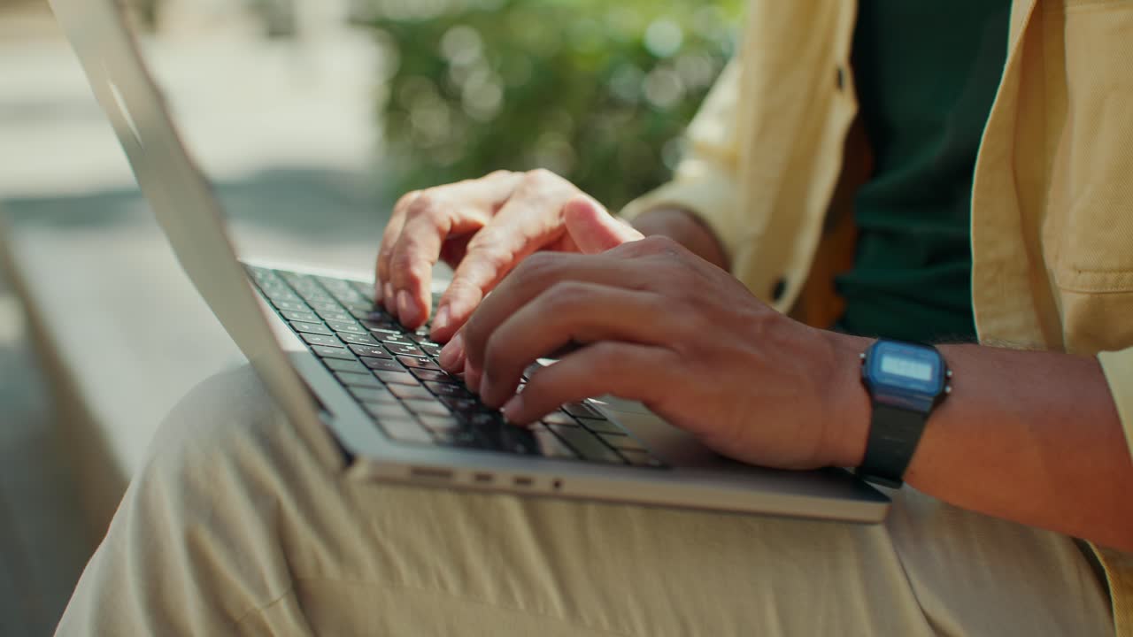 Typing on a laptop outdoors