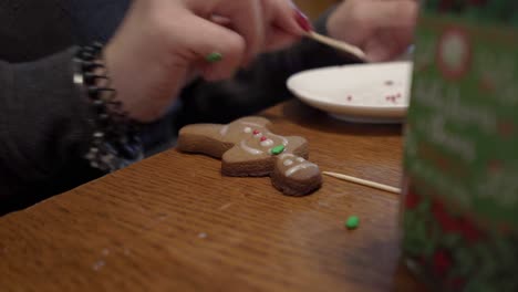 close-up shot of a lady putting icing on a gingerbread man