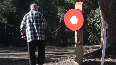 in a rural setting, a male volunteer engages with a country fire extinguisher. he expertly handles the device, showcasing essential fire safety techniques.