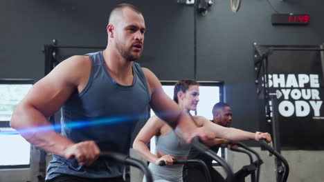 personas haciendo ejercicio en bicicletas de ejercicio en un gimnasio