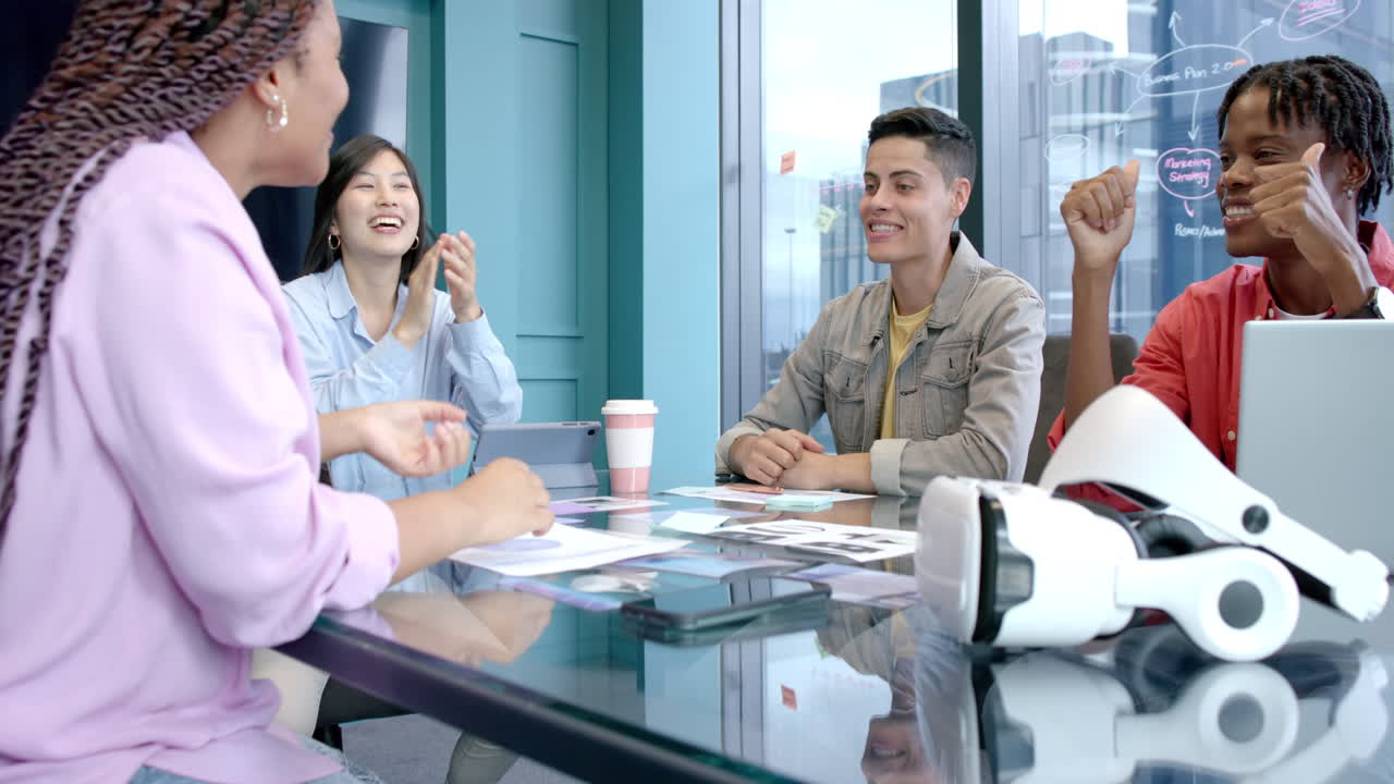Brainstorming ideas, diverse colleagues using VR headset and smartphone in office