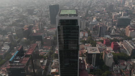 Fly-over-tall-office-building-Tilt-down-to-shot-of-heliport-on-roof-of-skyscraper.-Mexico-City,-Mexico.