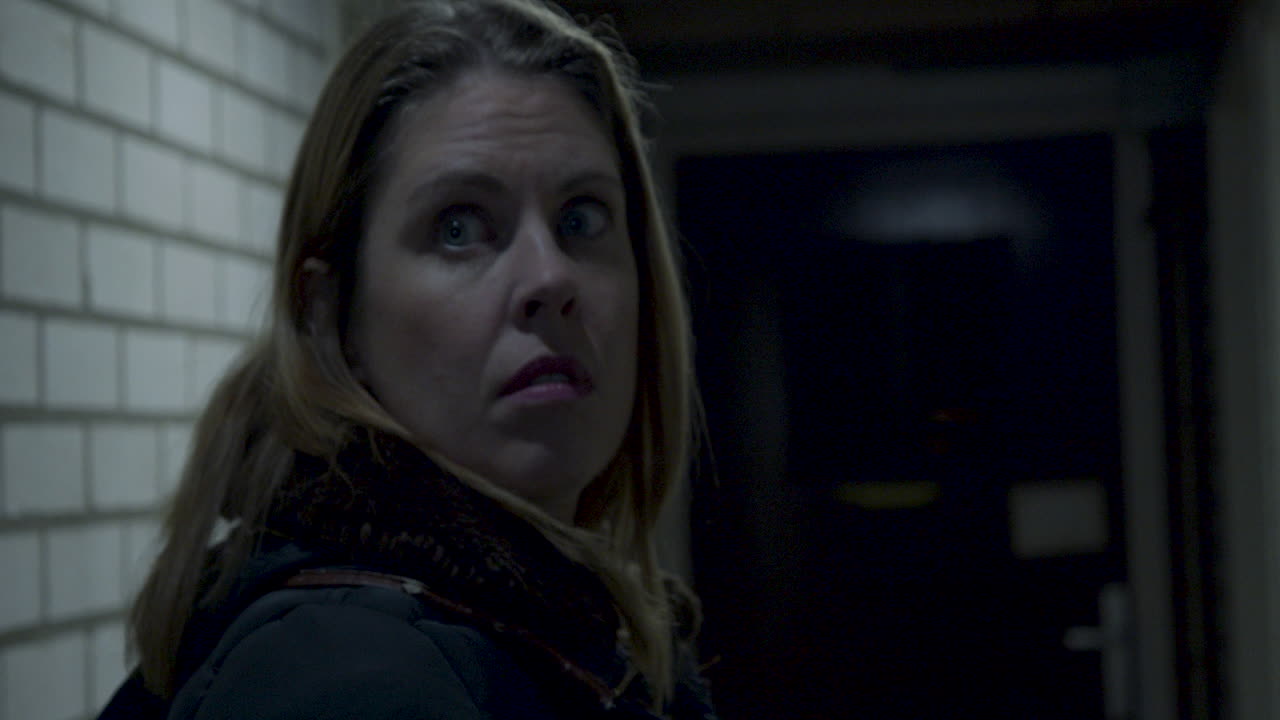 mujer en el trastero incómodamente mirando por encima del hombro y alejándose