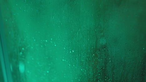 gotas de agua en una superficie de vidrio verde