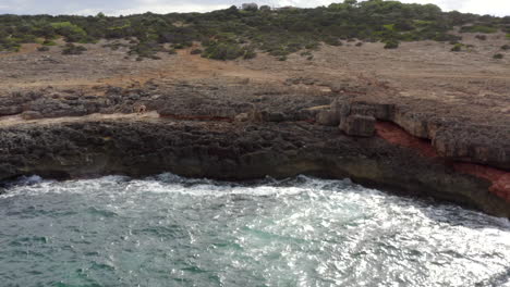 Antenne:-Flug-über-Das-Meer-Mit-Blick-Auf-Die-Klippenküste-An-Einem-Sonnigen-Tag-Auf-Der-Insel-Mallorca-Sonniges-Wetter,-Sonnenschein