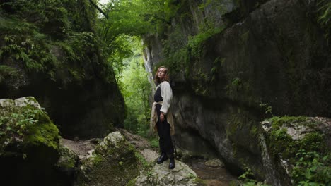 woman exploring a mossy canyon
