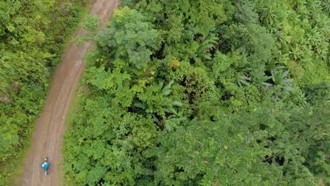 Aerial-shot-of-an-Indian-male-riding-through-the-mountains-route-in-a-remote-village,-Tamei,-Manipur,-India