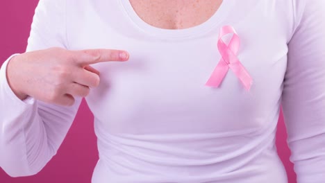 Video-of-midsection-of-pointing-caucasian-woman-wearing-pink-cancer-awareness-ribbon