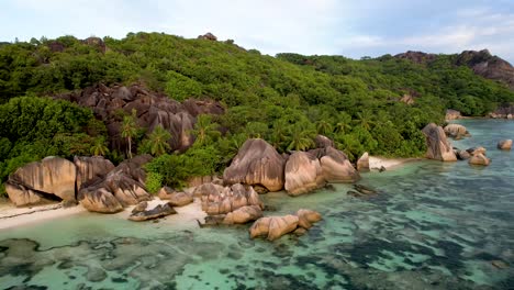 Vista-Aérea-De-La-Playa-De-Anse-Source-D&#39;argent-En-La-Isla-De-La-Digue-Seychelles-Con-Rocas,-Arena,-Palmeras-Y-Arrecifes-De-Coral