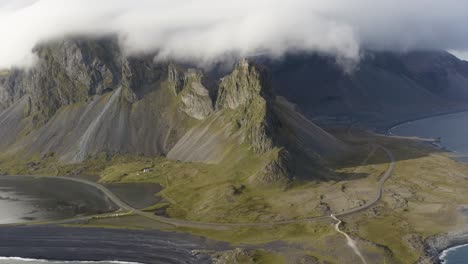 eystrahorn mountain covered with white clouds in iceland - aerial shot