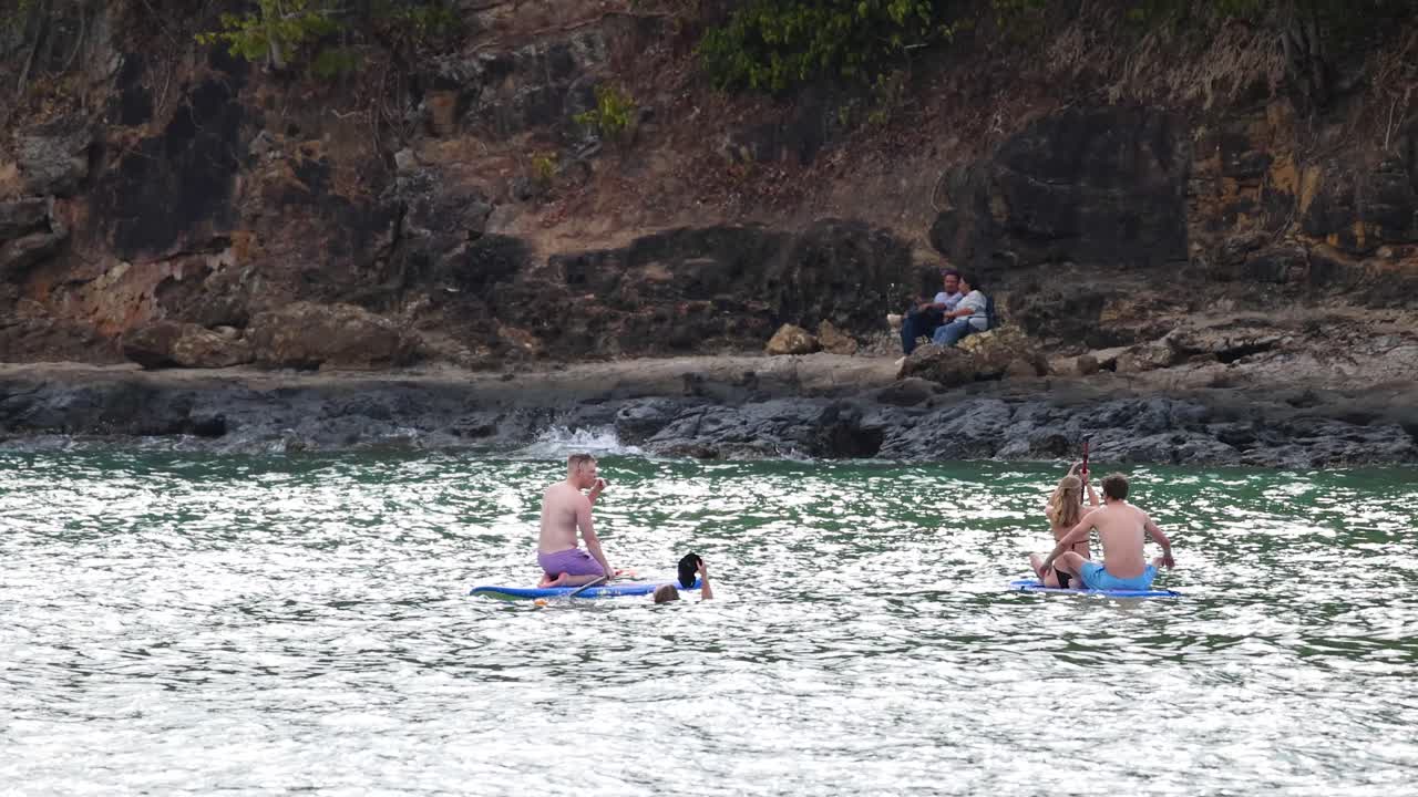 People Stand Up Paddleboarding at a Coastal Location