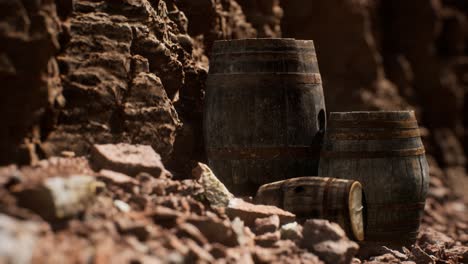 old wooden vintage wine barrels near stone wall in canyon