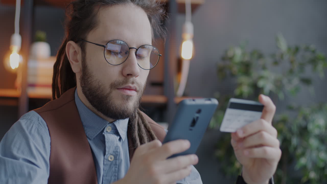 hombre usando teléfono inteligente y tarjeta de crédito para el pago en línea