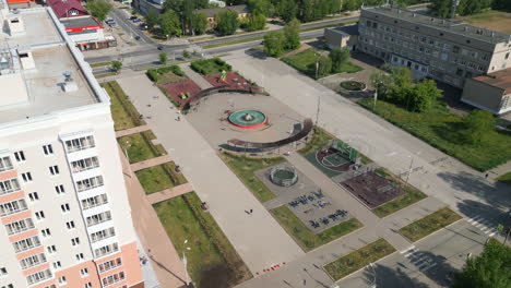 aerial view of a city square with park and residential buildings