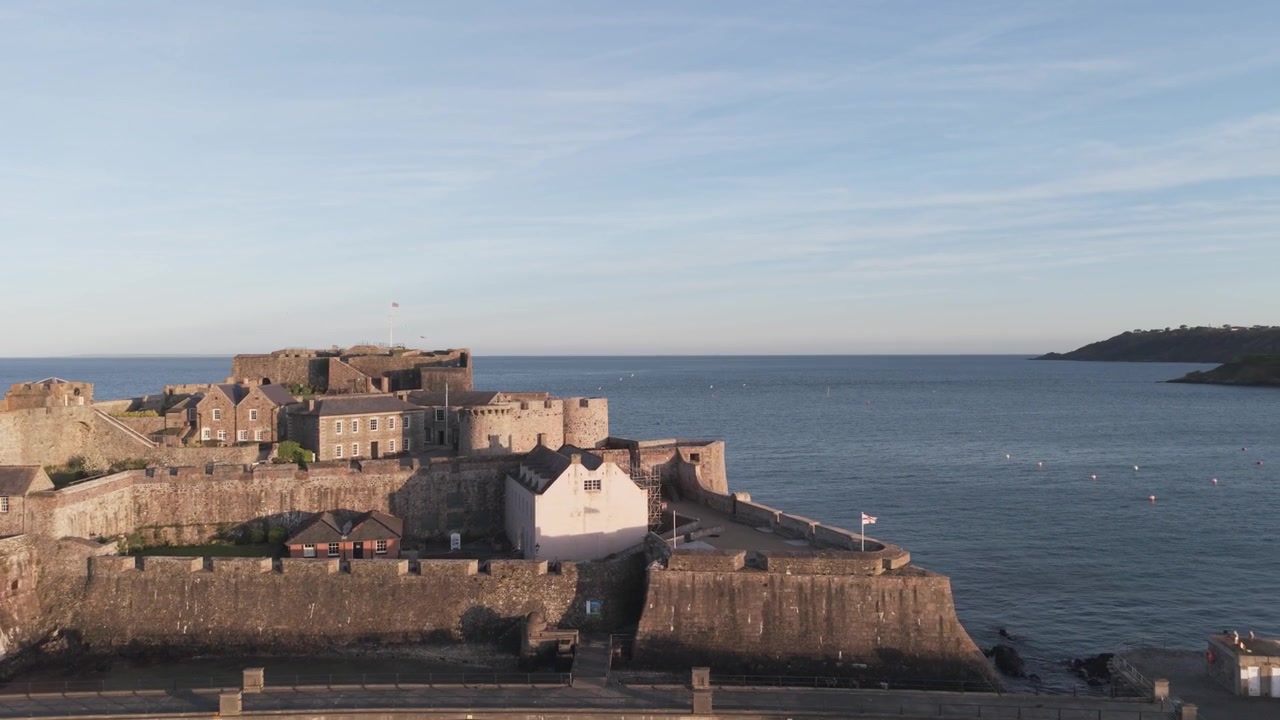 Castle Cornet St Peter Port Guernsey Isole del Canale. Vista ravvicinata del castello, del ponte e delle fortificazioni sotto il sole splendente con vista sul mare calmo nella baia di Havelet fino a St Martin’s Point