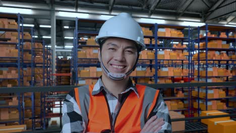 trabajador de almacén sonriendo frente a los estantes de almacenamiento