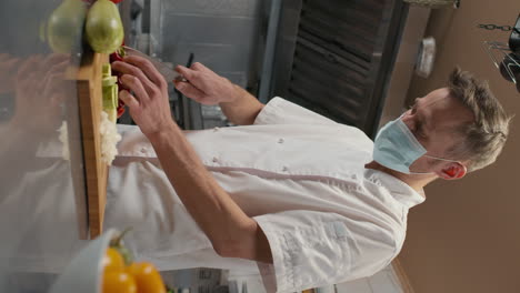 chef in mask cutting bell pepper