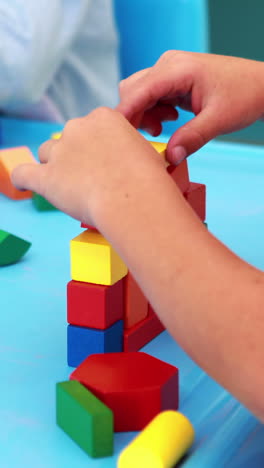 cute little boys playing with building blocks at table