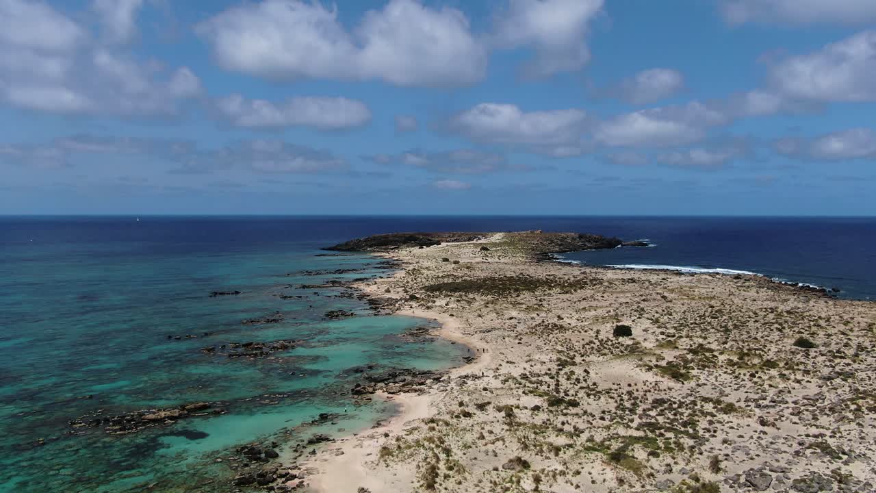 Long sandbank and crystal clear Aegean sea. Cinematic aerial forward