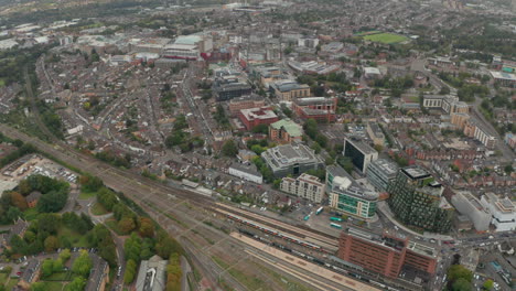 disparo aéreo sobre un tren de alta velocidad que pasa por la estación de watford junction mirando hacia la ciudad de watford