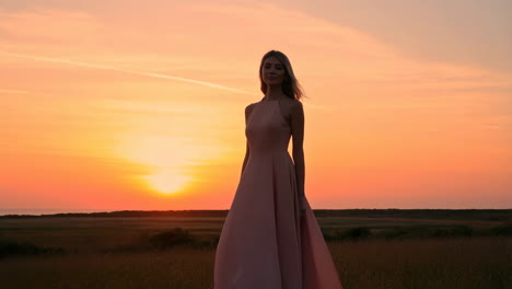 woman in dress at sunset in a field