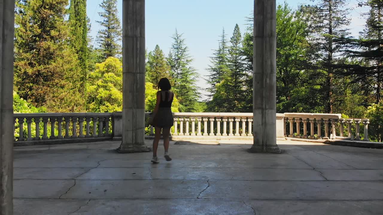 Happy excited caucasian woman spin out of joy on summer holiday vacation in scenic historical landmark outdoors. Concept freedom of travel vacation