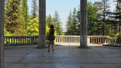 happy excited caucasian woman spin out of joy on summer holiday vacation in scenic historical landmark outdoors. concept freedom of travel vacation