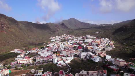 Aerial-orbit-view-of-Tamaimo-town-in-a-green-mountain-valley,-Tenerife