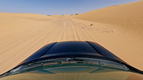 Driving-through-golden-sand-dunes-under-a-clear-blue-sky-in-the-Sahara-Desert