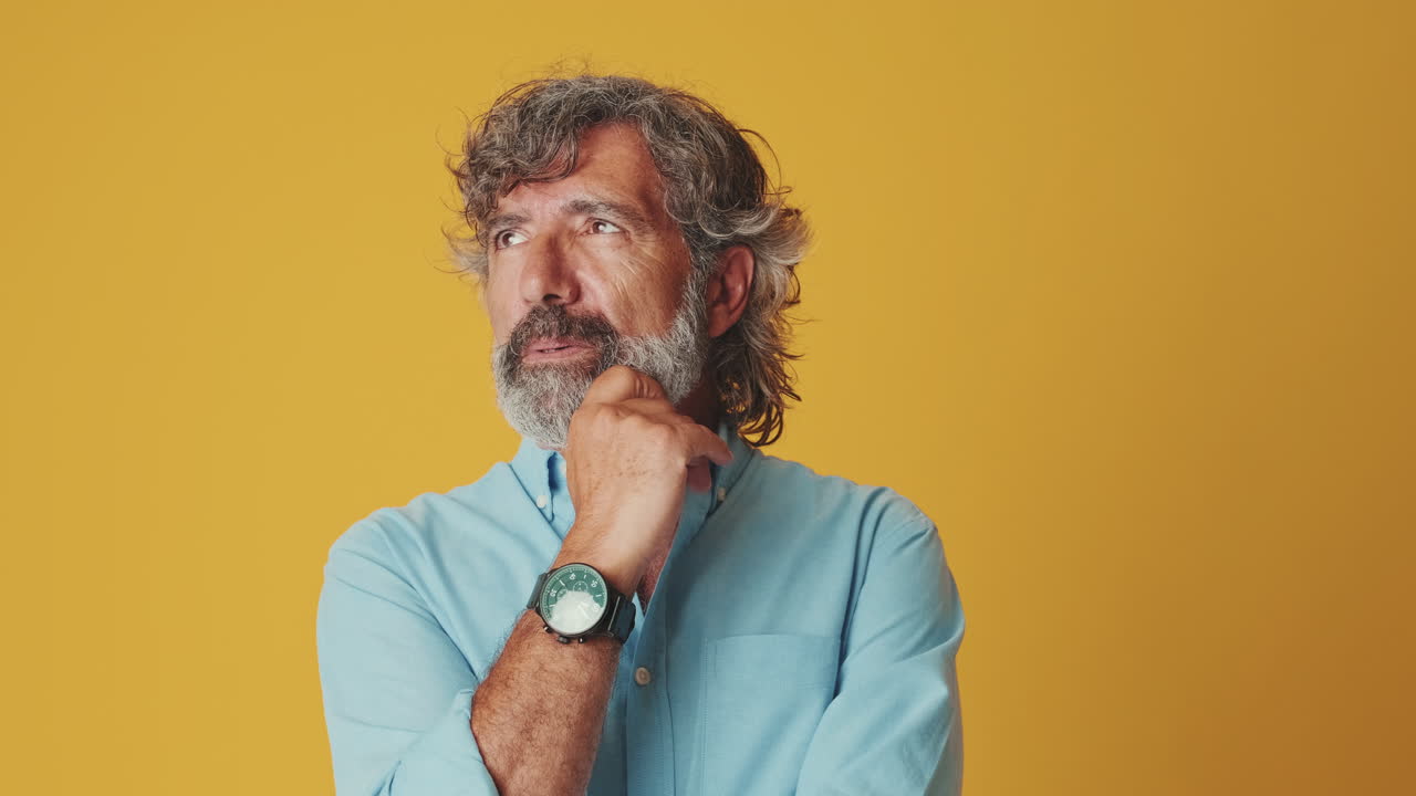 Thoughtful Mature Man Pondering an Idea on Yellow Background